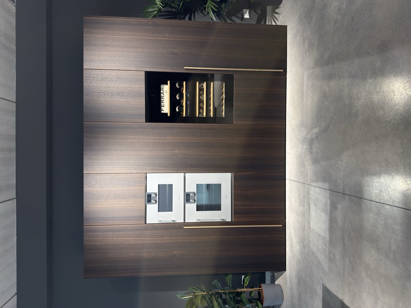 Showroom LA PI Cucine — parete attrezzata in rovere scuro con forno integrato e cantinetta vini