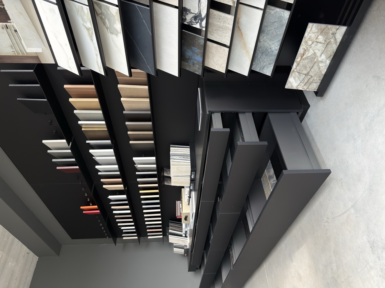 Showroom LA PI Cucine — parete materiali con campionature di marmi, legni e finiture